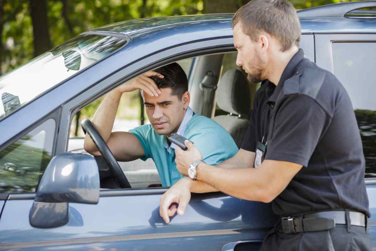 Un agente multa un uomo che ha violato il Codice della Strada