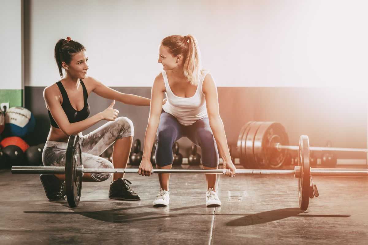 Ragazza si allena in palestra seguita dall'istruttrice