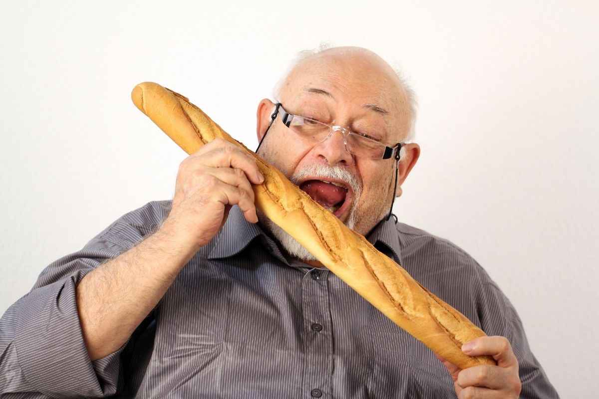 Signore addenta una baguette intera